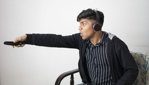 Young man looking away against white background