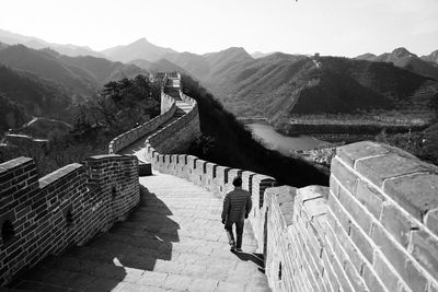 Man walking at great wall of china against sky