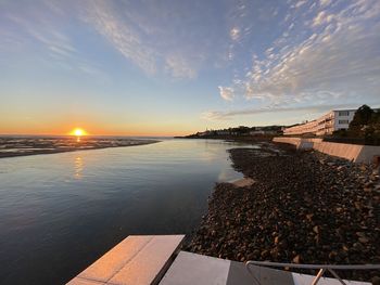 Scenic view of rocky beach at sunset