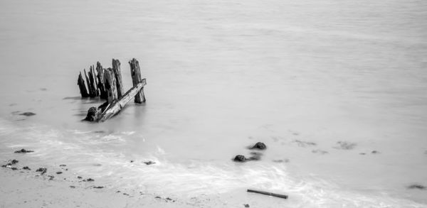 High angle view of wooden posts in sea