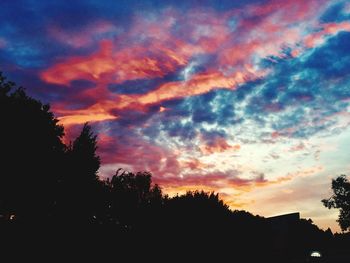 Low angle view of silhouette trees against sky