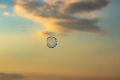 Low angle view of bubbles against sky at sunset