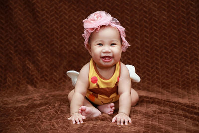 Portrait of cute baby girl sitting