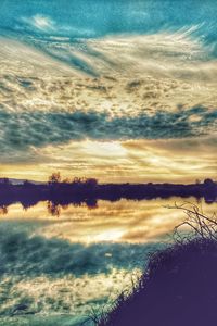 Scenic view of sea against dramatic sky during sunset