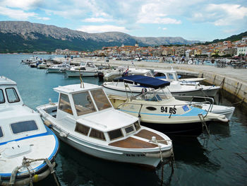 Boats moored in lake against sky