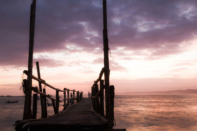 Pier over sea against sky during sunrise