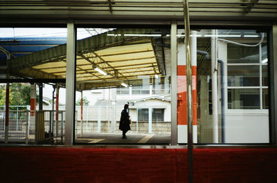 Man waiting at railroad station platform in city