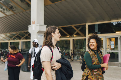 Male and female students walking in college campus