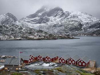 Scenic view of lake by snowcapped mountains against sky