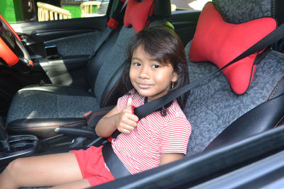 Portrait of cute girl sitting in car