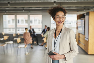 Portrait of smiling woman standing in office