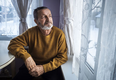 Man sitting by window at home