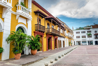 Footpath amidst buildings against sky