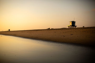 Scenic view of beach against sky during sunset