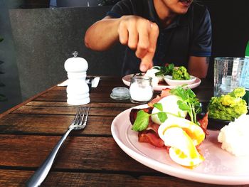 Midsection of man having food at table