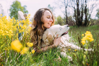 Young beautiful woman and her golden retriever dog having fun in summer