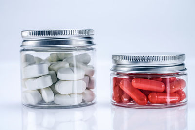 Close-up of glass jar on table against white background