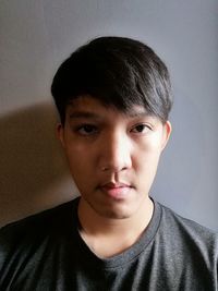 Portrait of young man against wall