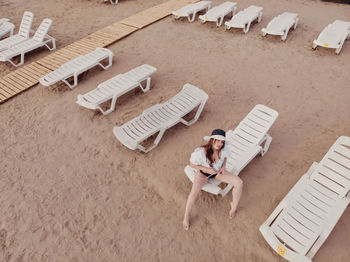 High angle view of young woman sitting on chair