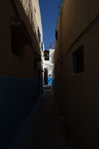 Alley amidst buildings against clear sky