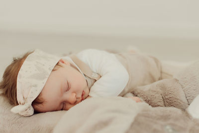 Cute baby girl sleeping on bed at home