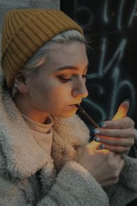 Close-up portrait of a girl holding cigarette