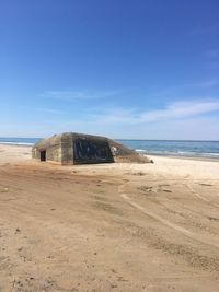 Scenic view of beach against blue sky
