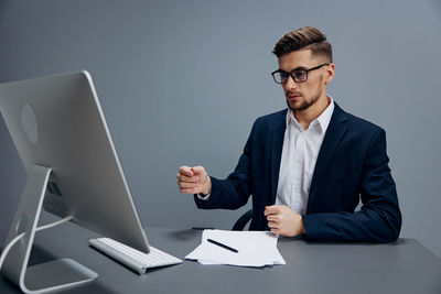 Portrait of businessman using laptop at office