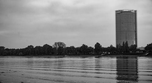 Scenic view of lake by buildings against sky