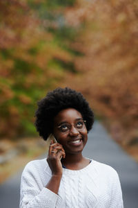 Woman talking on phone while standing outdoors