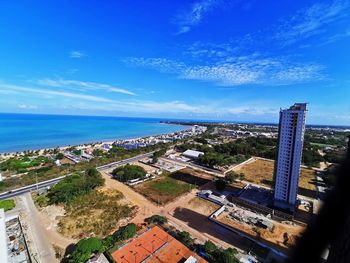 High angle view of buildings by sea against blue sky