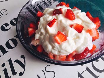 Close-up of strawberry slices with yogurt in bowl on table
