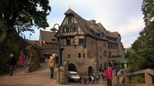 Group of people outside building against sky