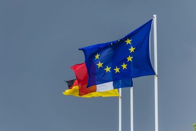 Flags waving against clear sky