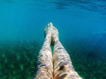 Low section of woman swimming in sea