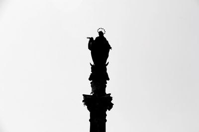 Low angle view of silhouette statue against clear sky