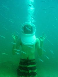 Man showing ok sign while swimming in sea