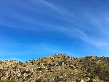 Low angle view of mountain against blue sky