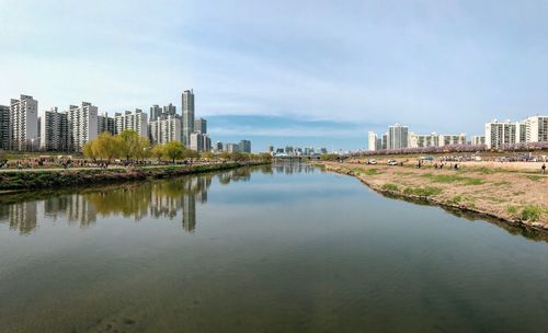 River by buildings against sky in city