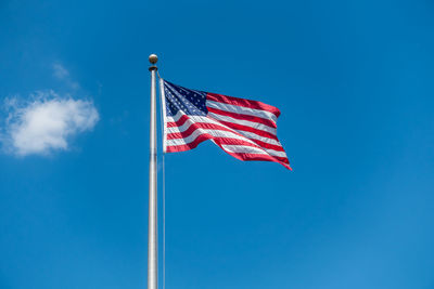 Low angle view of flag against blue sky