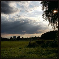 Scenic view of field against cloudy sky