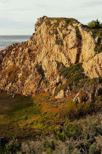 Rock formations by sea against sky
