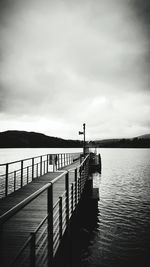 Pier over calm sea against sky