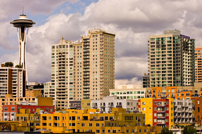 Buildings in city against cloudy sky