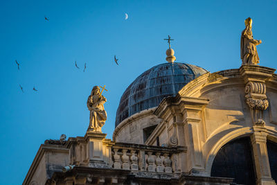 Low angle view of statue in city against clear sky