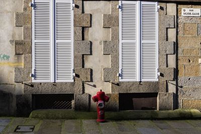 Full length of red pipe on brick wall