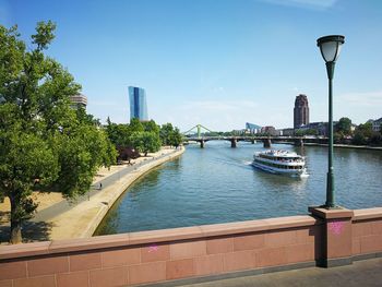 Scenic view of river by buildings against sky