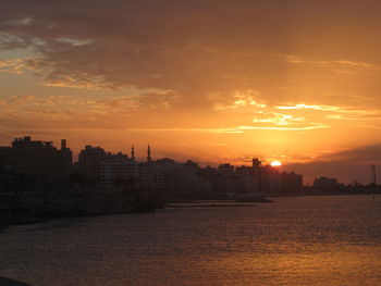 Silhouette buildings against sky during sunset