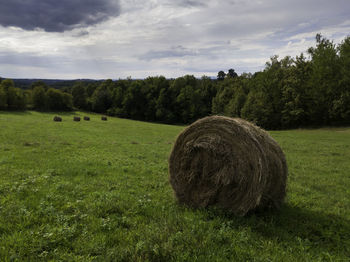 Hay bales on field against sky