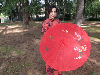 Portrait of smiling young woman standing on land